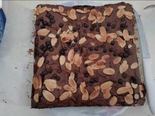 Shiny and crust brownies with almond and chocolate chips topping.